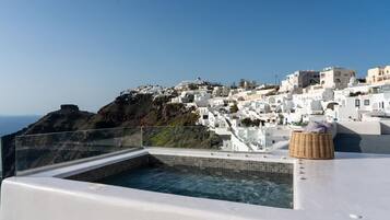 A rooftop pool with a clear view of a white-washed coastal town.