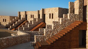 A stone building with multiple levels and wooden staircases. - Beresheet by Isrotel exclusive (Ramat Negev)