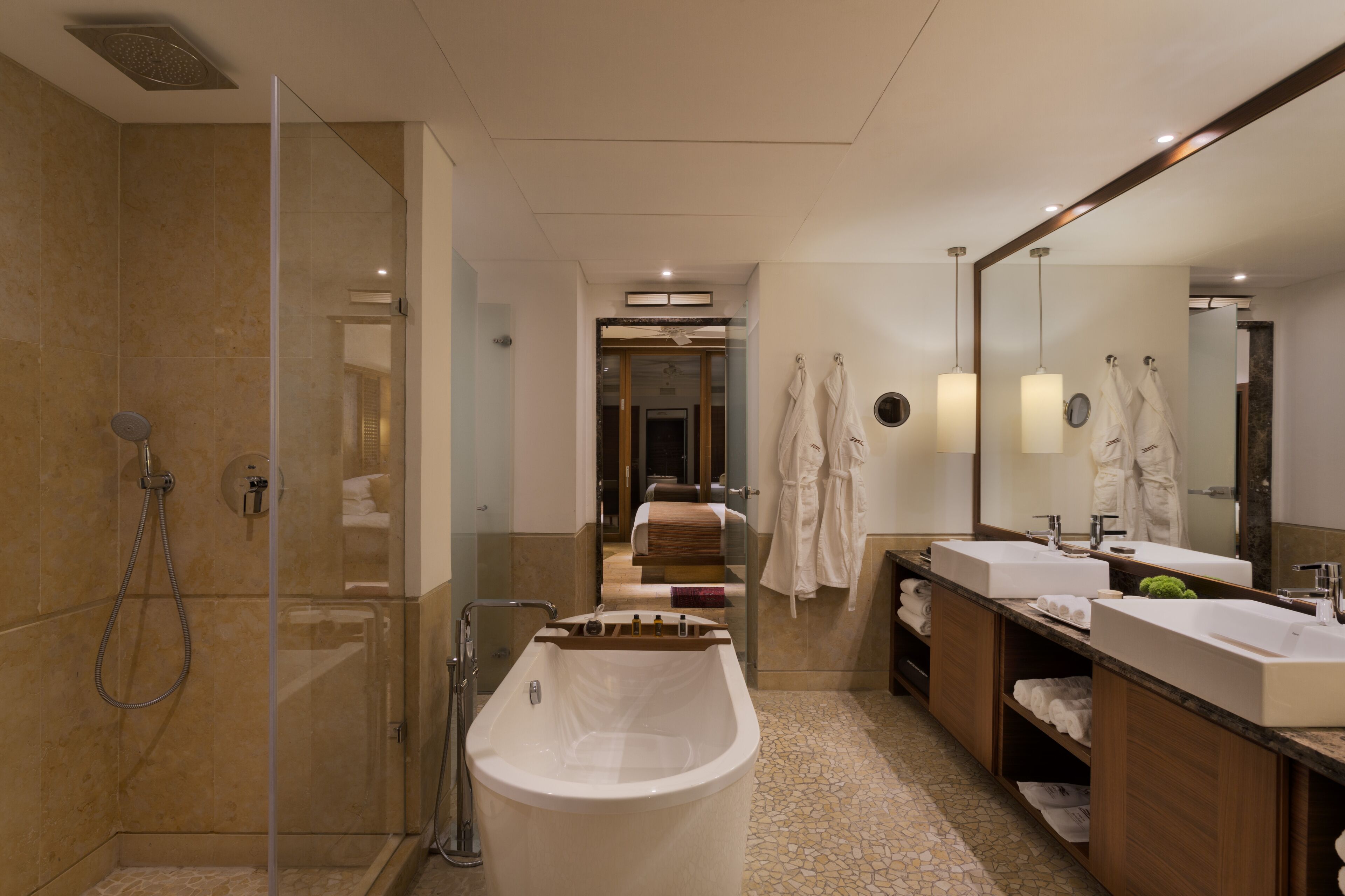 A modern bathroom with a glass-enclosed shower, a freestanding bathtub, and a vanity with two sinks.
