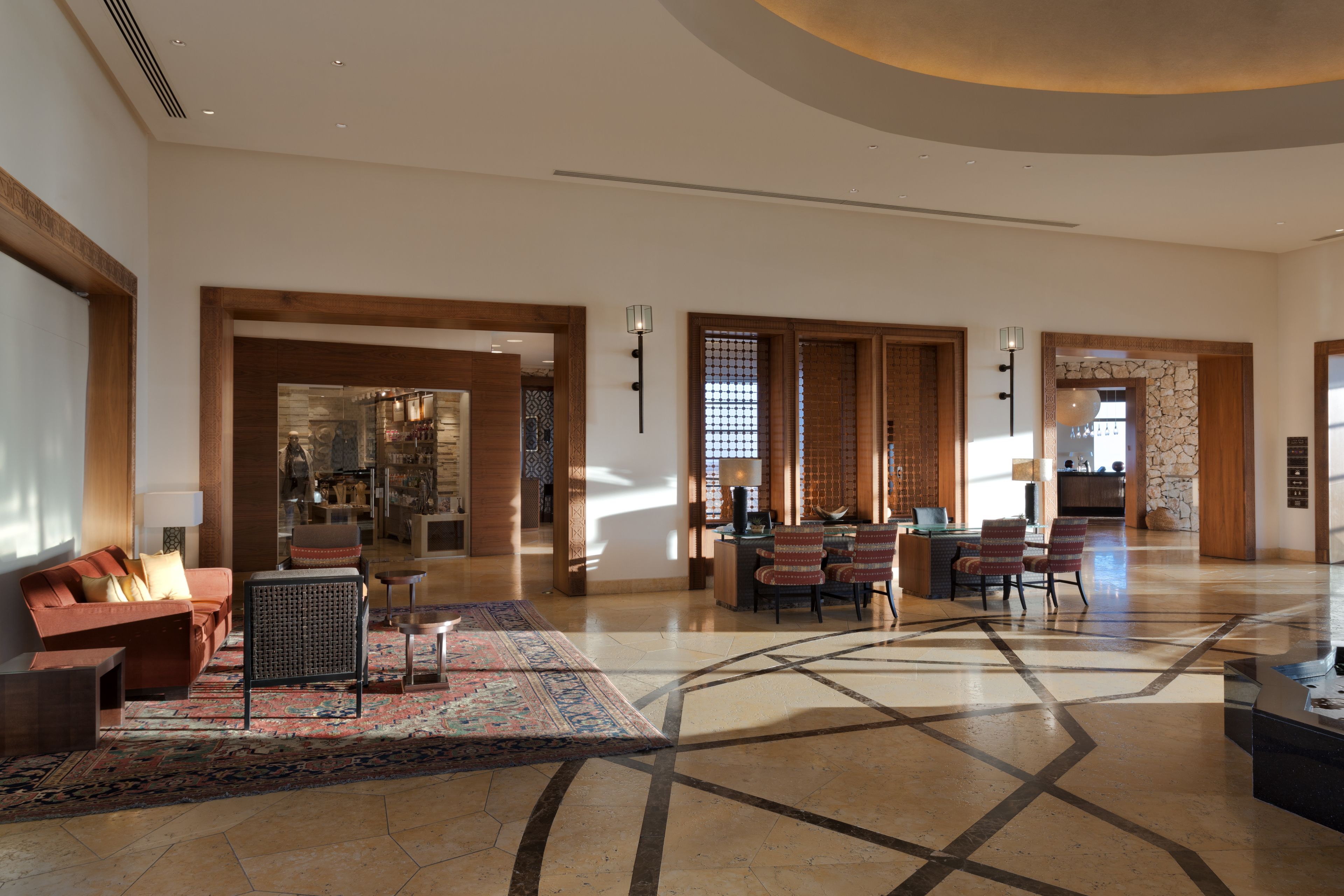 A spacious lobby with a seating area, a reception desk, and a view into the dining area.