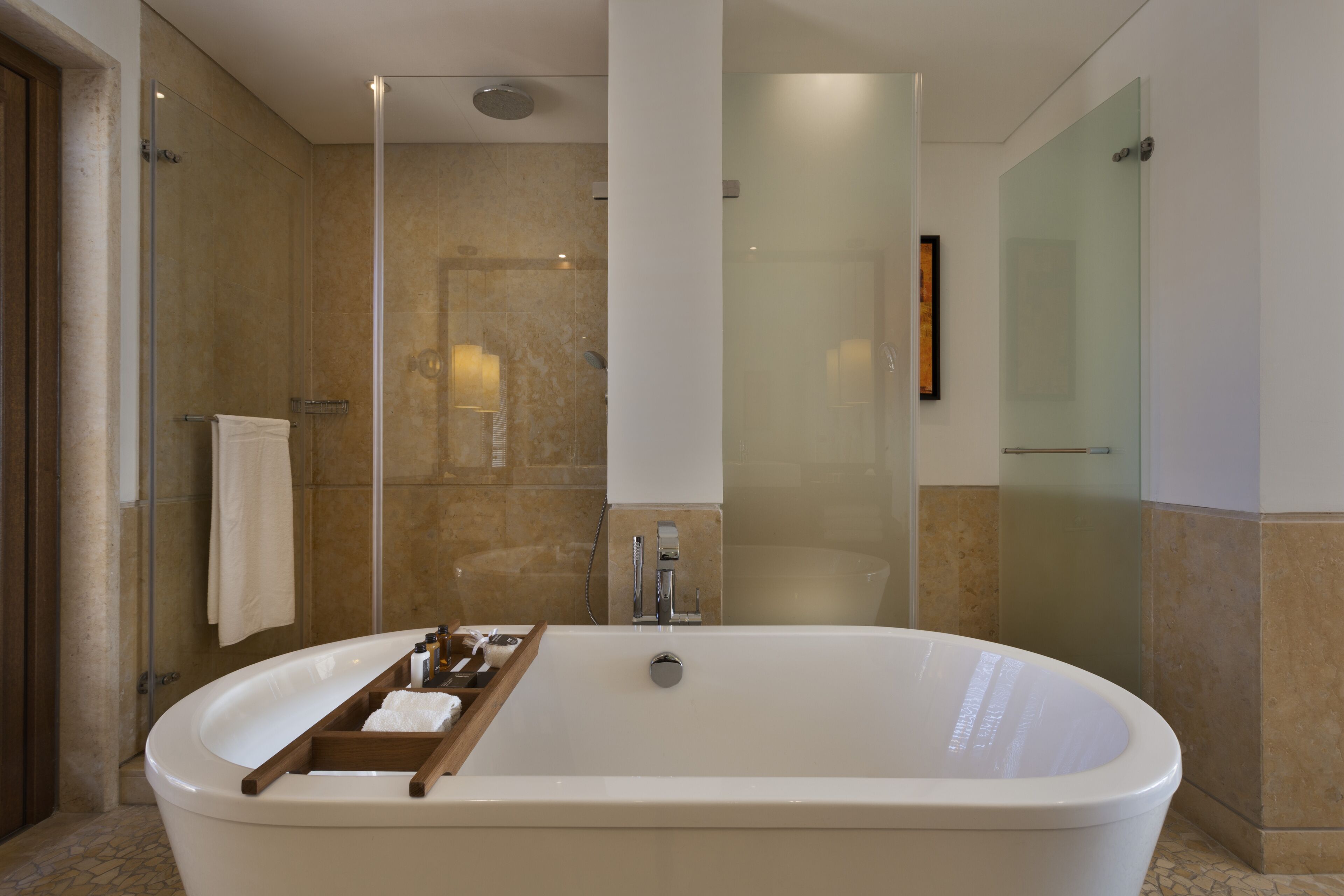 Une salle de bain moderne avec une baignoire sur pieds, une douche en verre et un mur recouvert de carreaux de marbre.