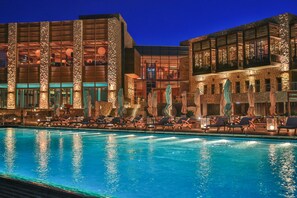 A hotel with a swimming pool, lounge chairs, and a stone facade. - Beresheet by Isrotel exclusive (Ramat Negev)