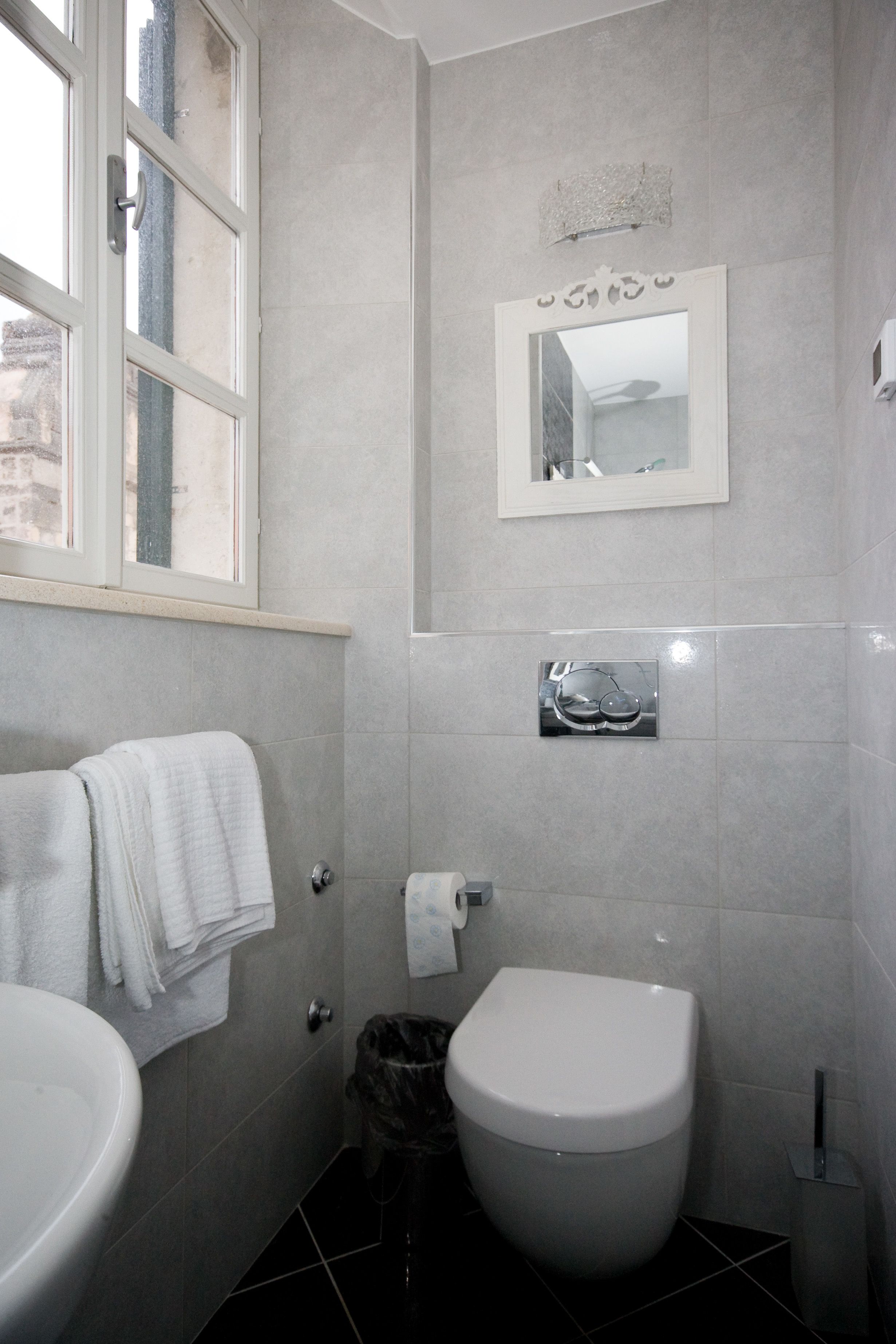Ein Badezimmer mit Toilette, Waschbecken und Spiegel.