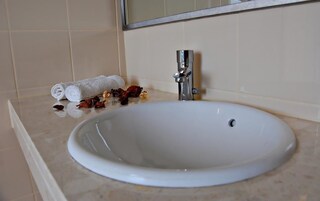Une salle de bain avec un lavabo blanc, un miroir et une serviette.