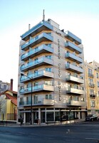 Egy többemeletes épület erkélyekkel, egy „LISBON CITY HOTEL” feliratú táblával, és egy utca az épület előtt.