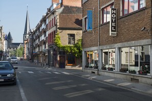 A hotel with a signboard, a street view, and a church spire in the background. - Hotel Cathedral Gent Centrum (Ghent)