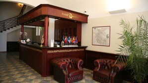 A lobby with a reception desk, two leather armchairs, a staircase, and a map on the wall. - Draakon Hotel (Tartu)