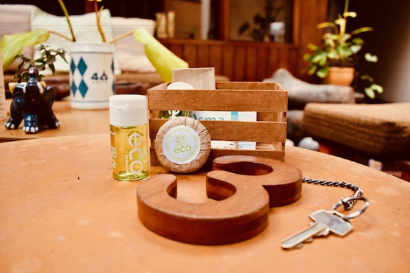 A wooden table with a keychain, a bottle, and a wooden box with a label.