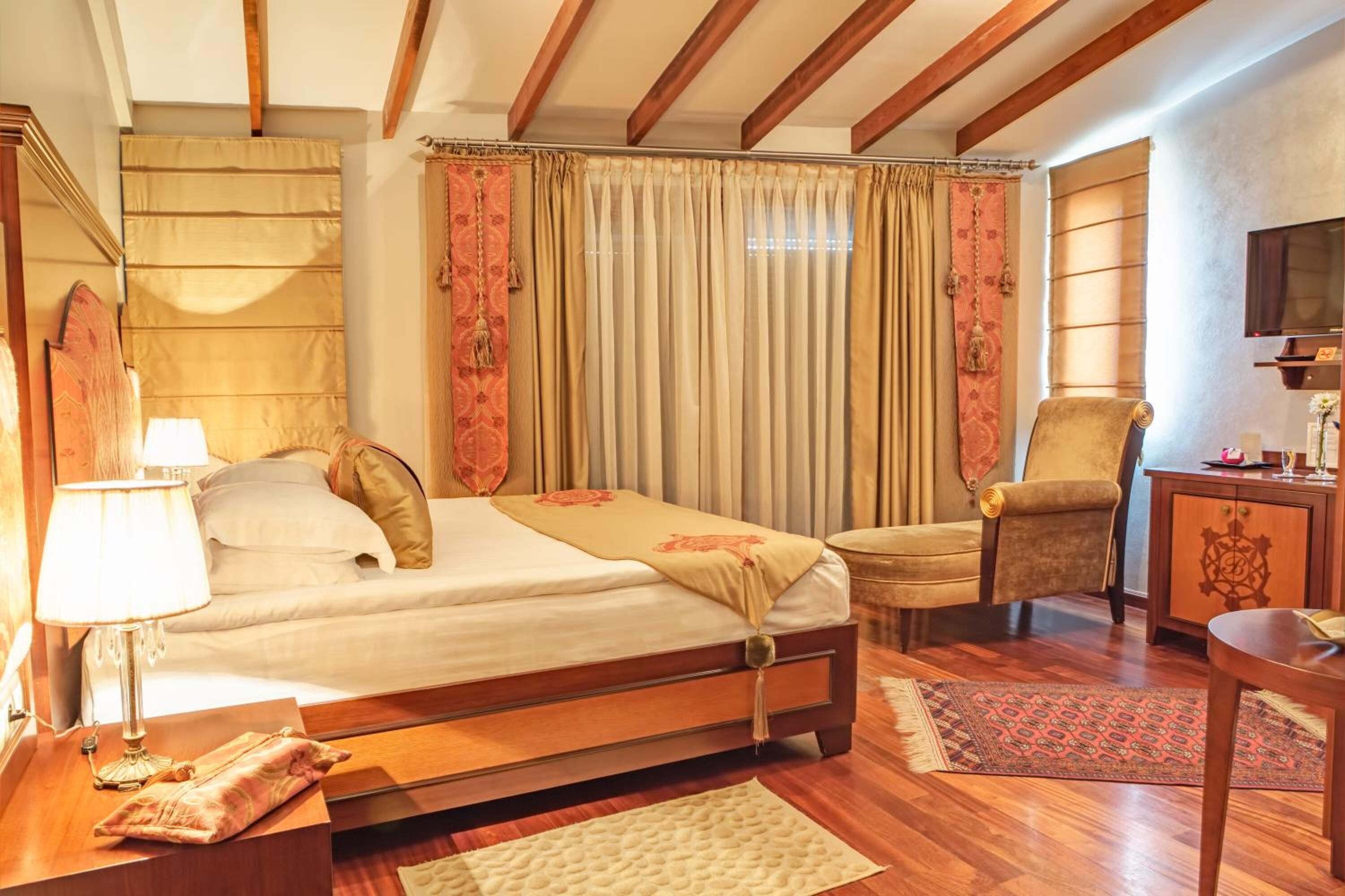 Een slaapkamer met een houten bed, een stoel, een bureau en een televisie.