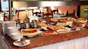 A buffet with various dishes and a glass display case. - Hostería Posta Sur (El Calafate)