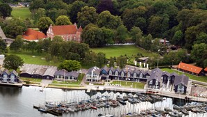 A marina with numerous boats docked, surrounded by residential buildings and lush greenery. - Hotel Strandtangen (Skive)