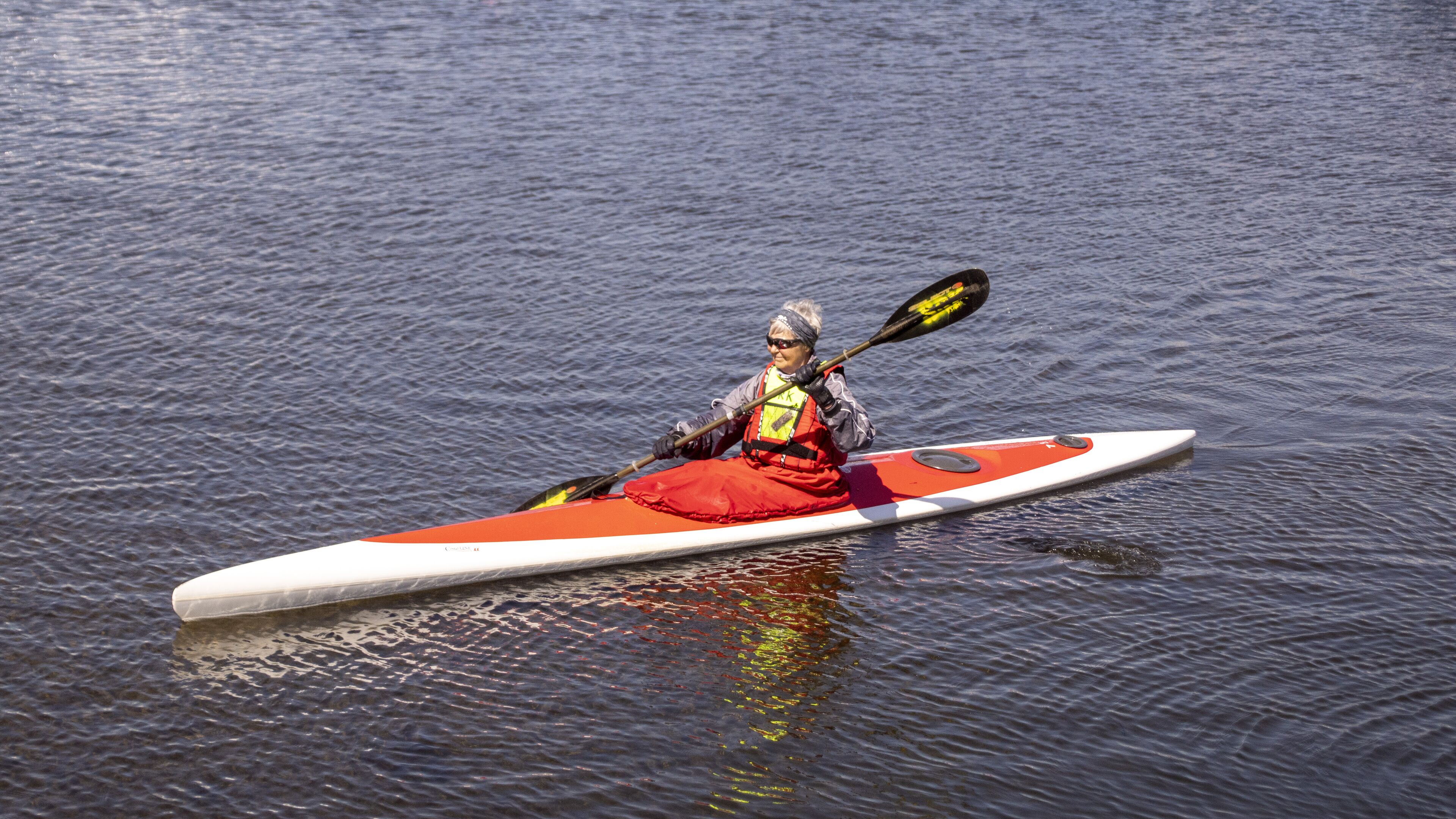 A person kayaking on a calm body of water.