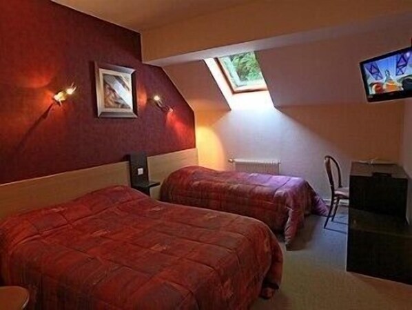 A bedroom with two beds, a desk, a chair, a TV, and a skylight. - Hôtel Restaurant Le Bourguignon (Beze)