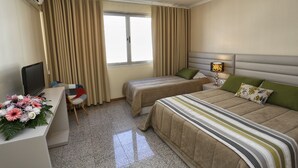 A hotel room with two beds, a desk with a TV, and a window with curtains. - Oporto City Center Apartments (Porto)