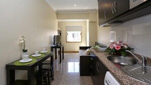 A compact kitchen with a dining area, a built-in oven, and a sink. - Oporto City Center Apartments (Porto)