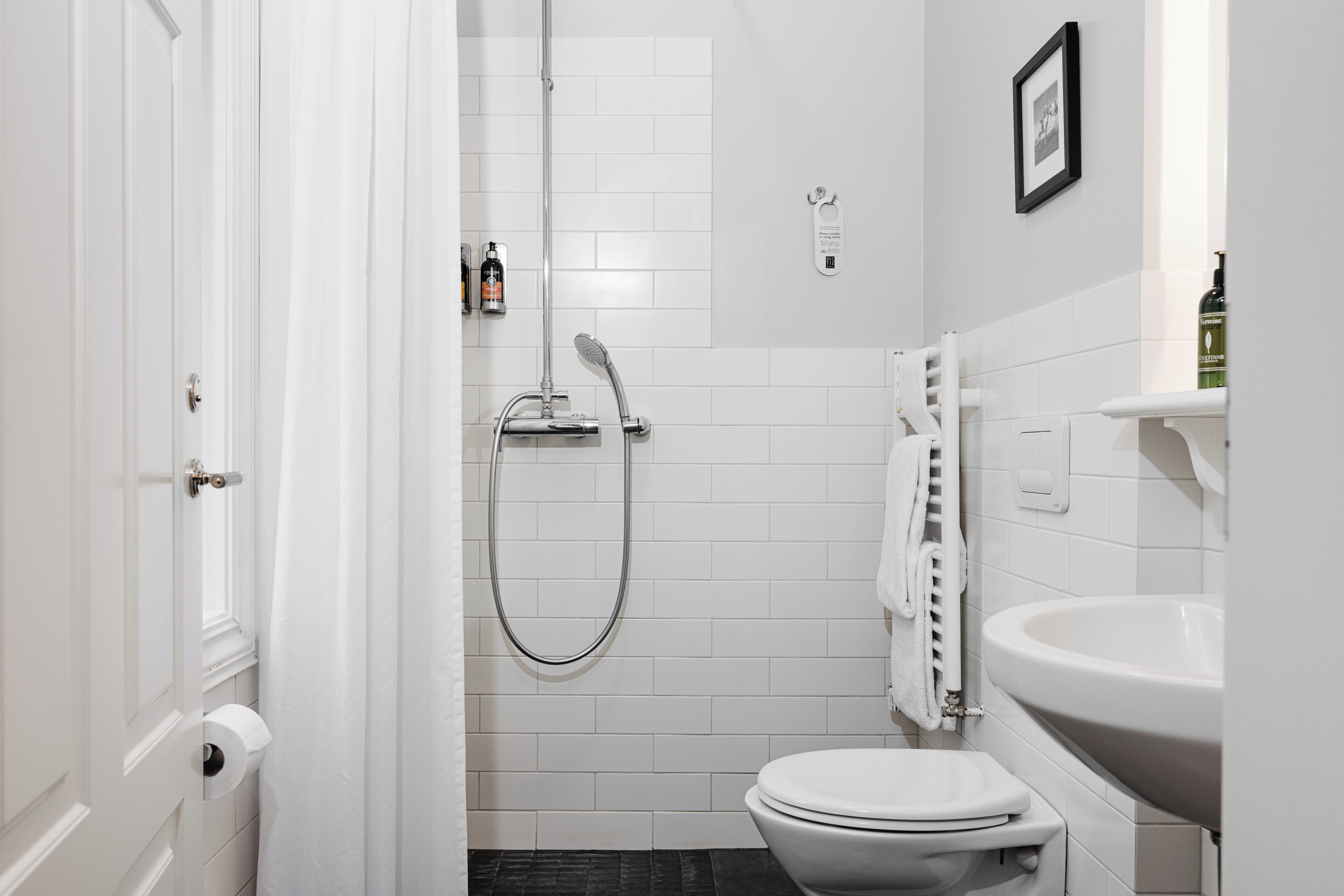 A compact bathroom with a toilet, a sink, and a shower.