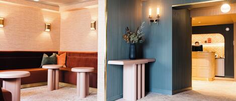 Un interior moderno con una zona de estar, un pequeño bar y un jarrón decorativo.