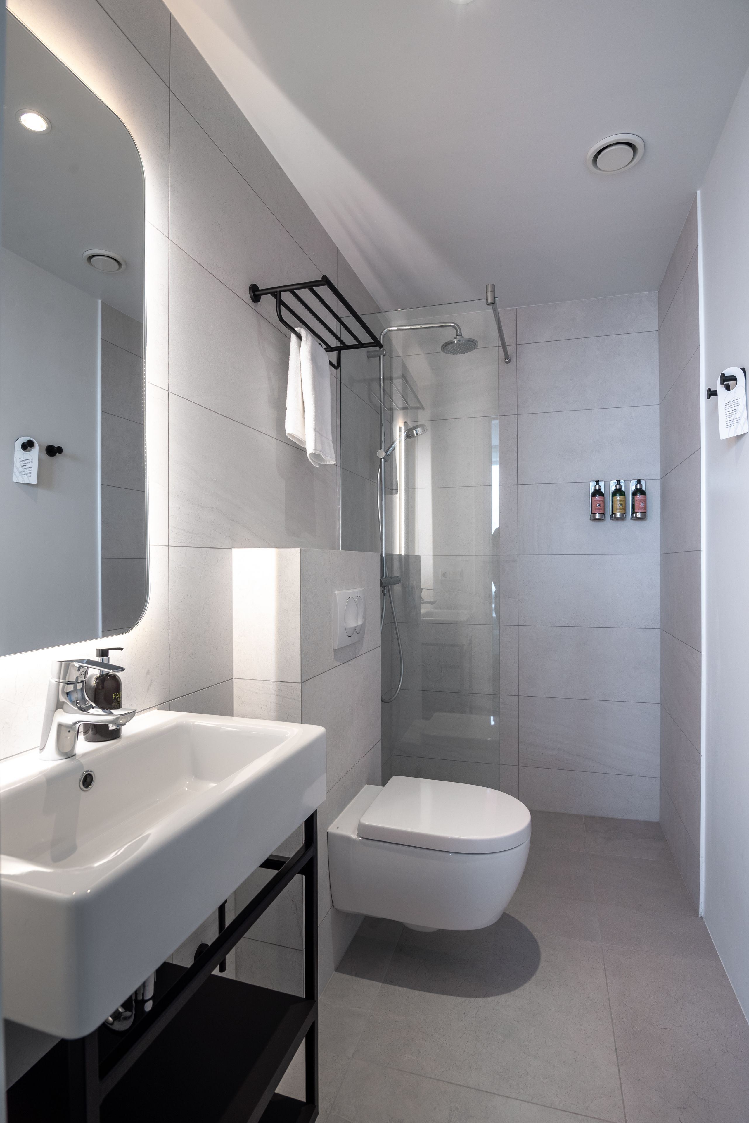Ein modernes Badezimmer mit Waschbecken, Toilette und Duschkabine aus Glas.