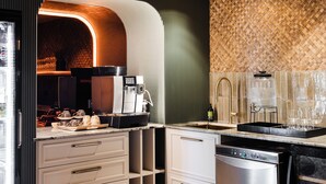 A modern kitchen with a built-in coffee machine, a sink, and a dishwasher.