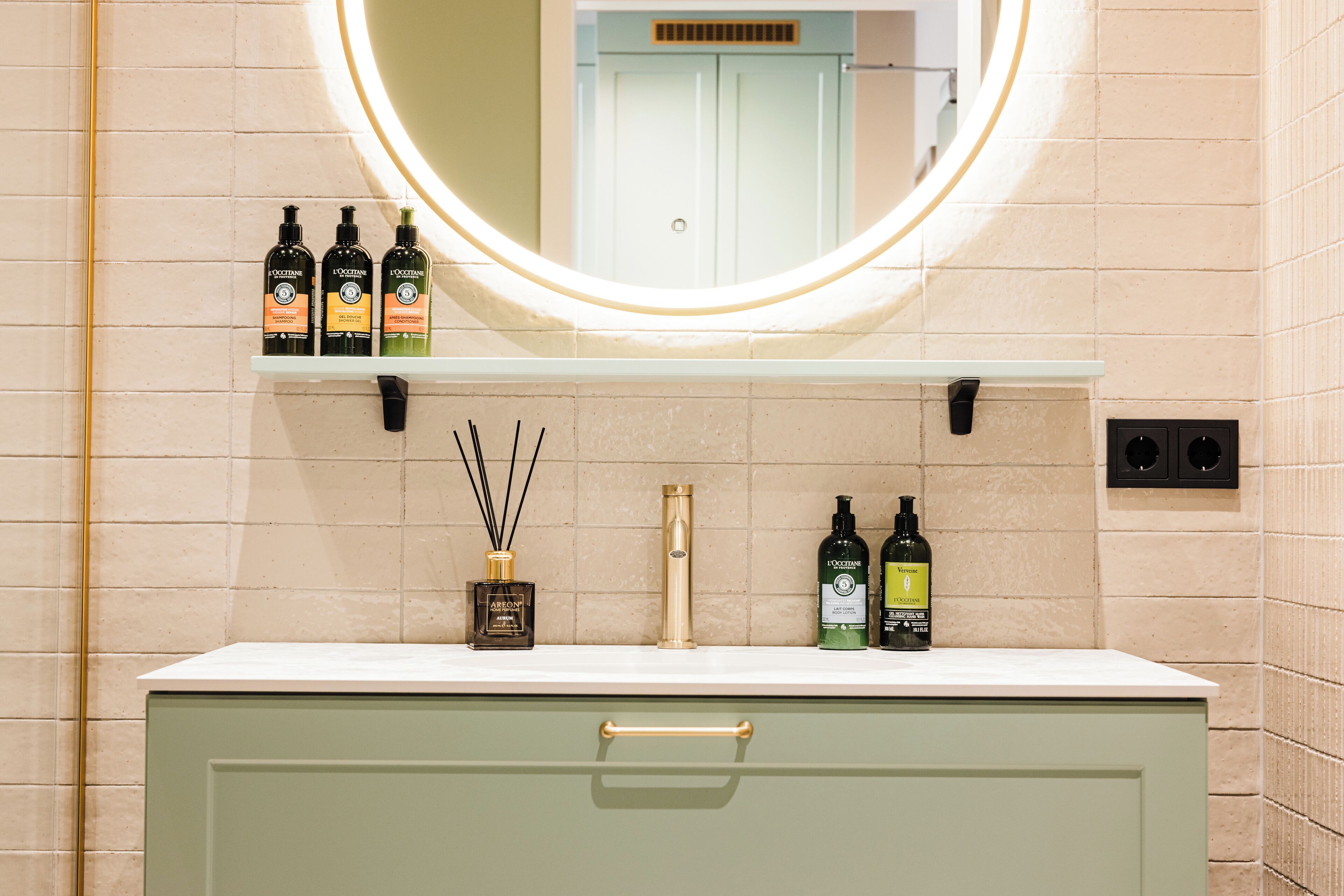 A bathroom with a round mirror, a white countertop, and various toiletries.