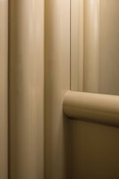 Ein Teil eines Raumes mit einer beigen Wand und einer gewölbten Fußleiste.