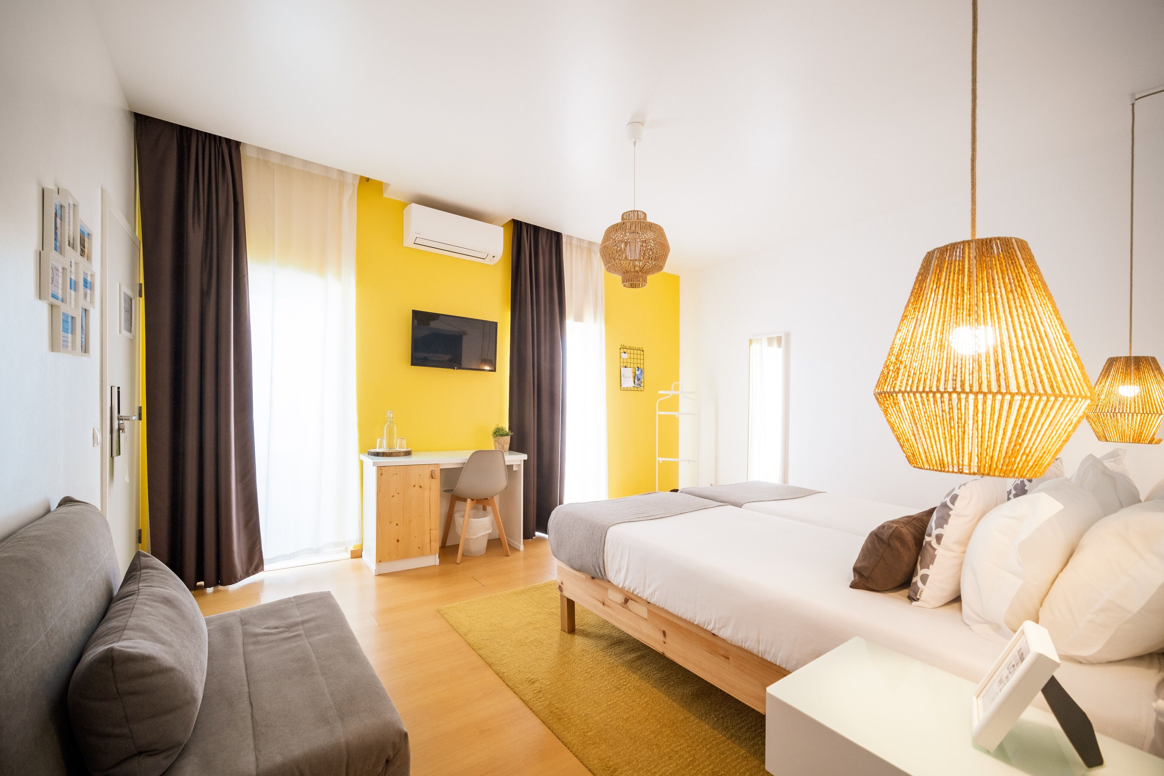 Une chambre d’hôtel moderne équipée d’un lit, d’un canapé, d’un bureau et d’un coin repas.