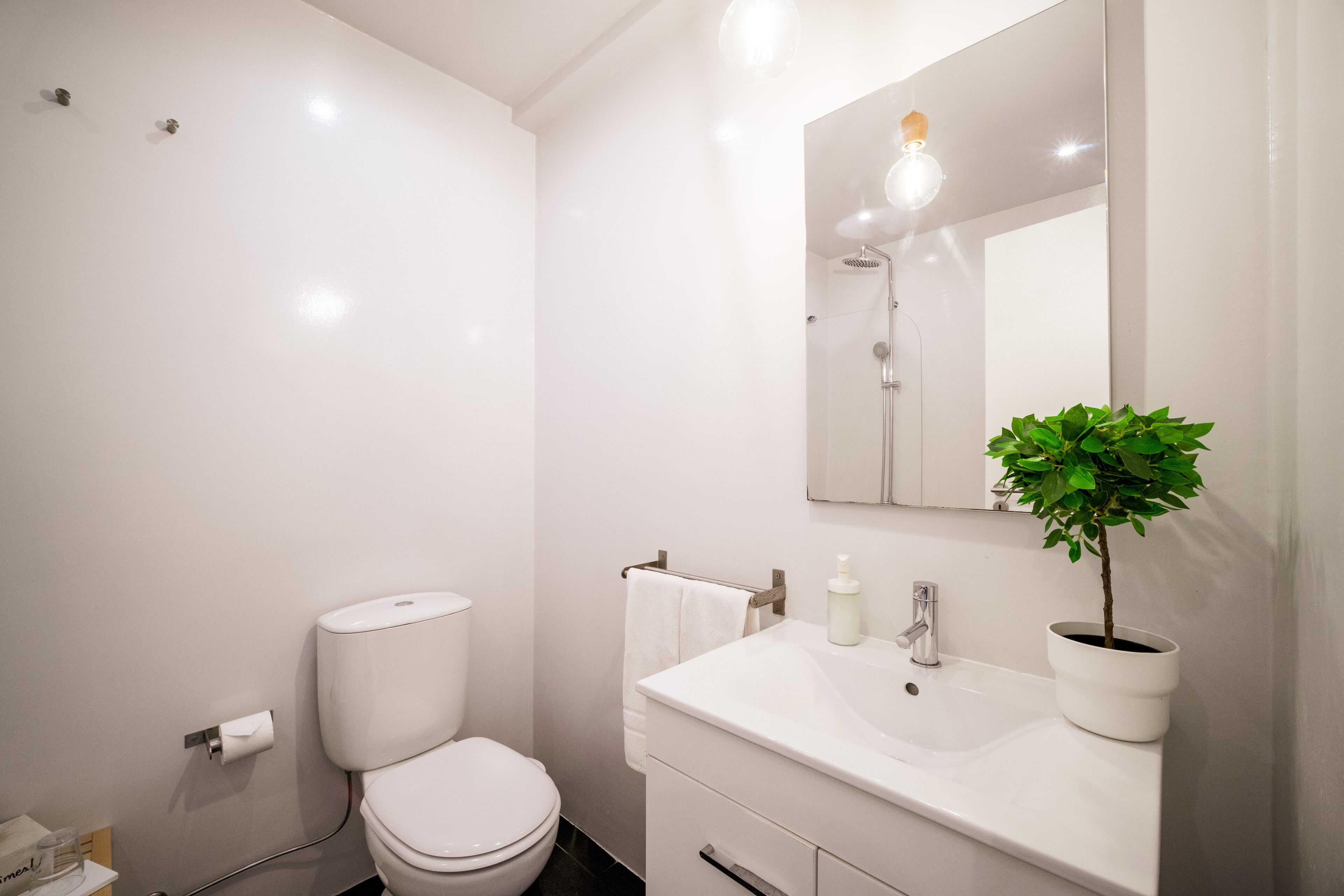 A modern bathroom with a toilet, sink, and mirror.