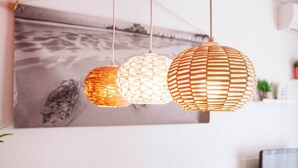A dining area with a wooden table, chairs, and hanging paper lanterns.