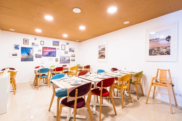 A dining area with tables and chairs, a ceiling with recessed lighting, and framed pictures on the walls. - Casa Azul Sagres - Rooms & Apartments (Vila do Bispo)