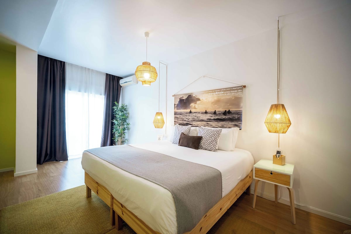 Een moderne slaapkamer met een groot bed, nachtkastjes en uitzicht op de omgeving.