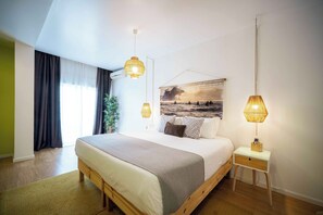 A modern bedroom with a large bed, bedside tables, and a view of the outdoors. - Casa Azul Sagres - Rooms & Apartments (Vila do Bispo)