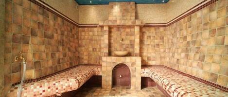 Un cuarto de spa con paredes de azulejos y bancos.