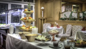 Een buffet met diverse gerechten en een fruitpresentatie in drie niveaus.
