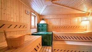 Een houten sauna met banken en een houten emmer.