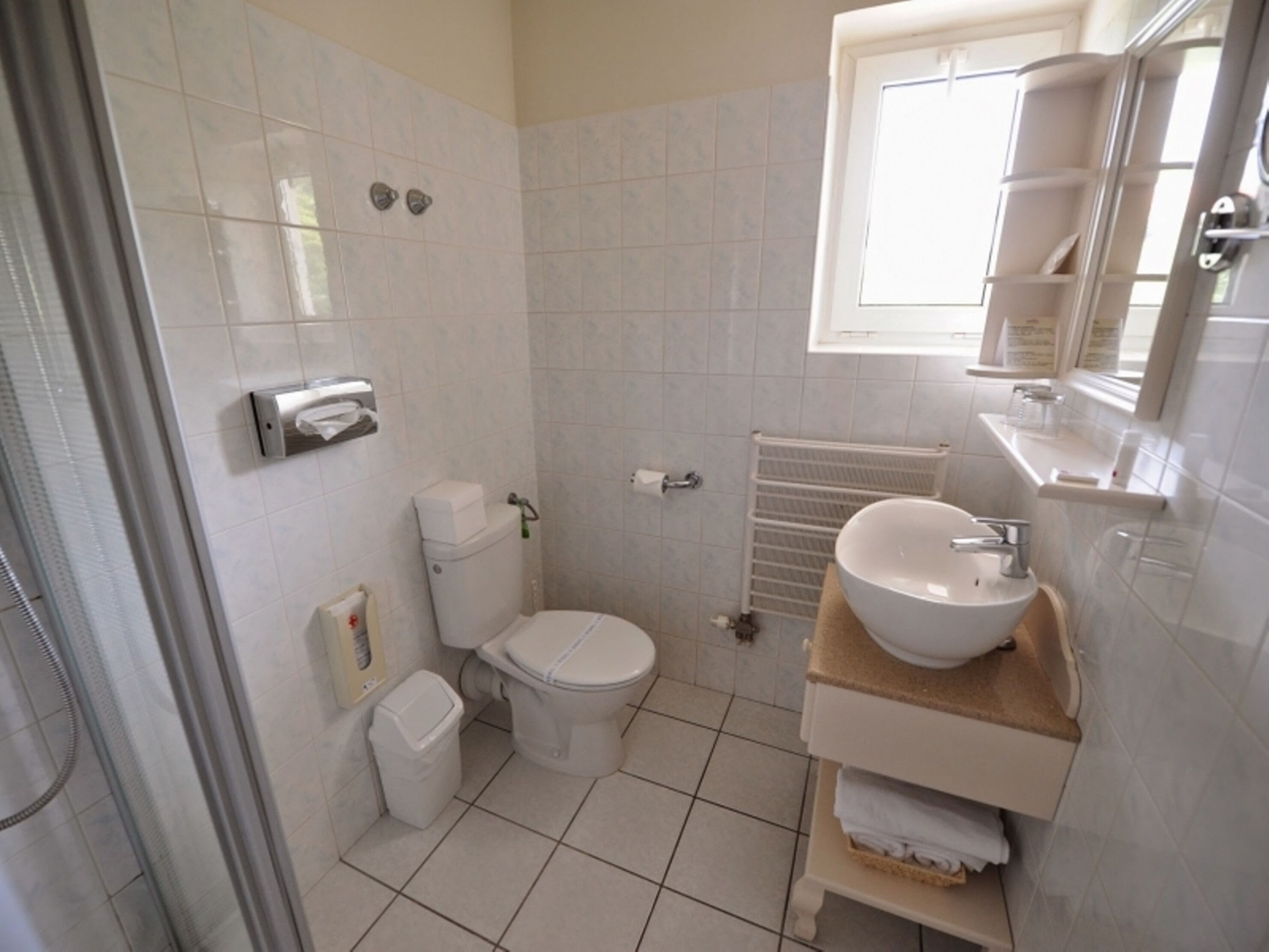 A bathroom with a toilet, sink, and shower.