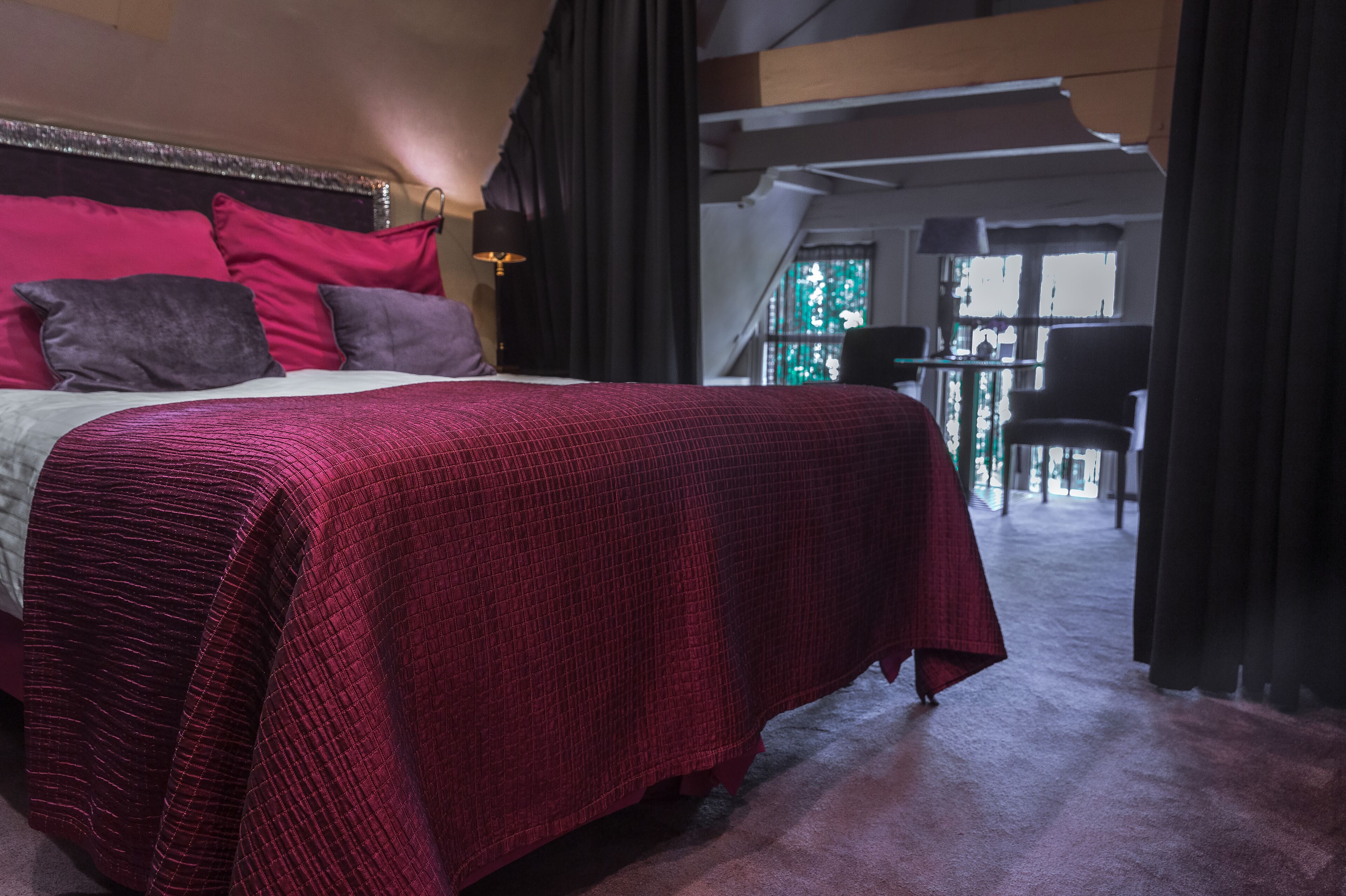 Een slaapkamer met een groot bed, een hoofdeinde en uitzicht op een balkon.