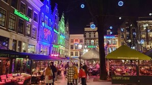A bustling street scene with illuminated buildings, including a Heineken sign and a Bavaria restaurant. - Hotel Sebastian's (Amsterdam)