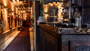 A bar area with a counter, decorative lights, and a patterned tile backsplash. - Hotel Sebastian's (Amsterdam)