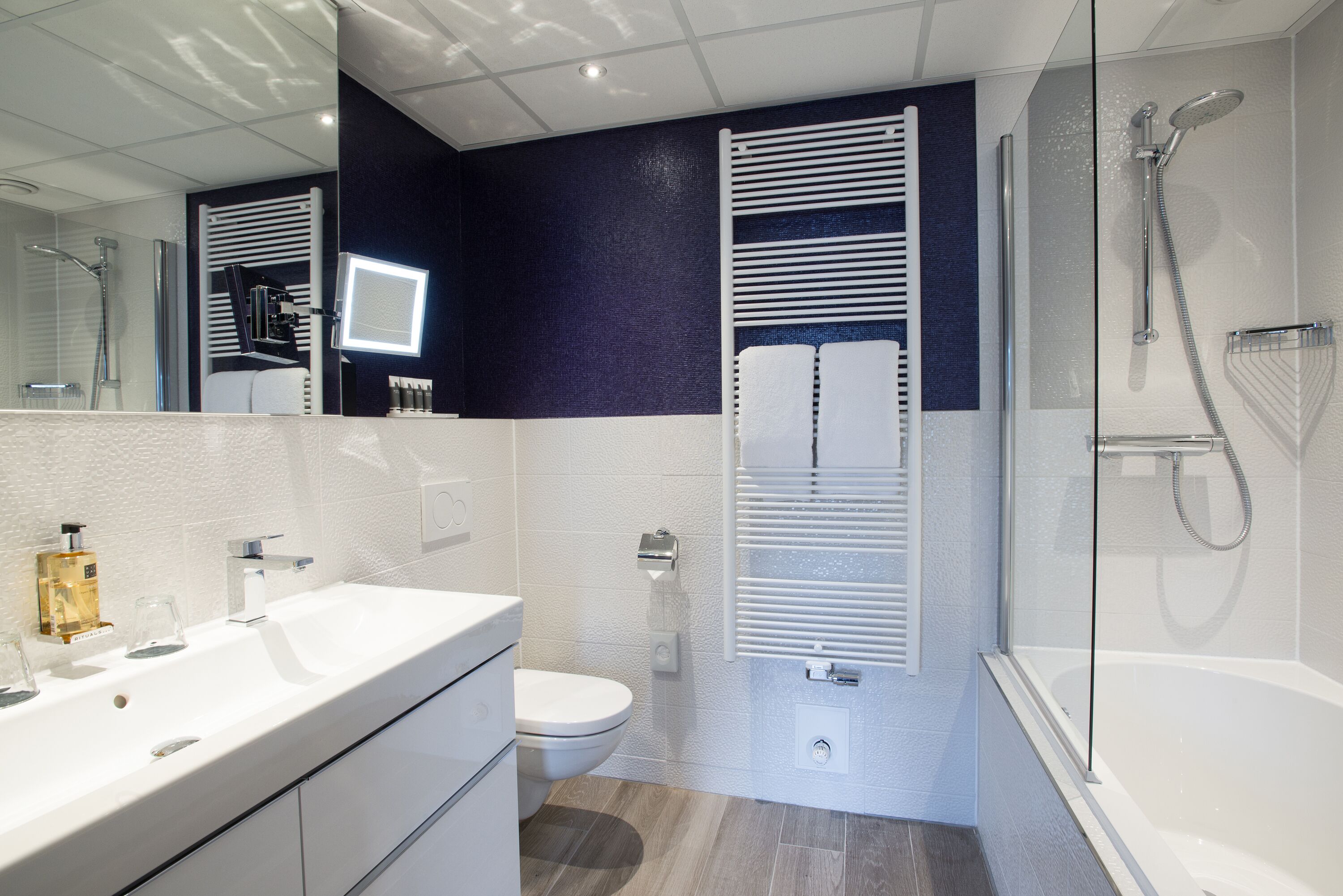 A modern bathroom with a white sink, toilet, and bathtub.