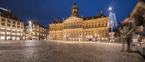 A historic building with a prominent dome and classical architecture, situated in a cobblestone square.