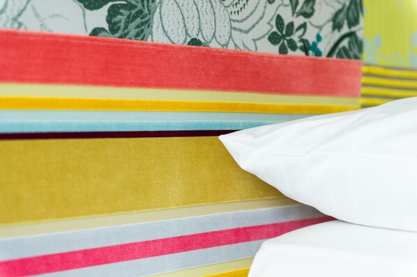 A stack of colorful books with a white cloth partially covering them. - Hotel APART Welcoming I Urban Feel I Design (Rotkreuz)
