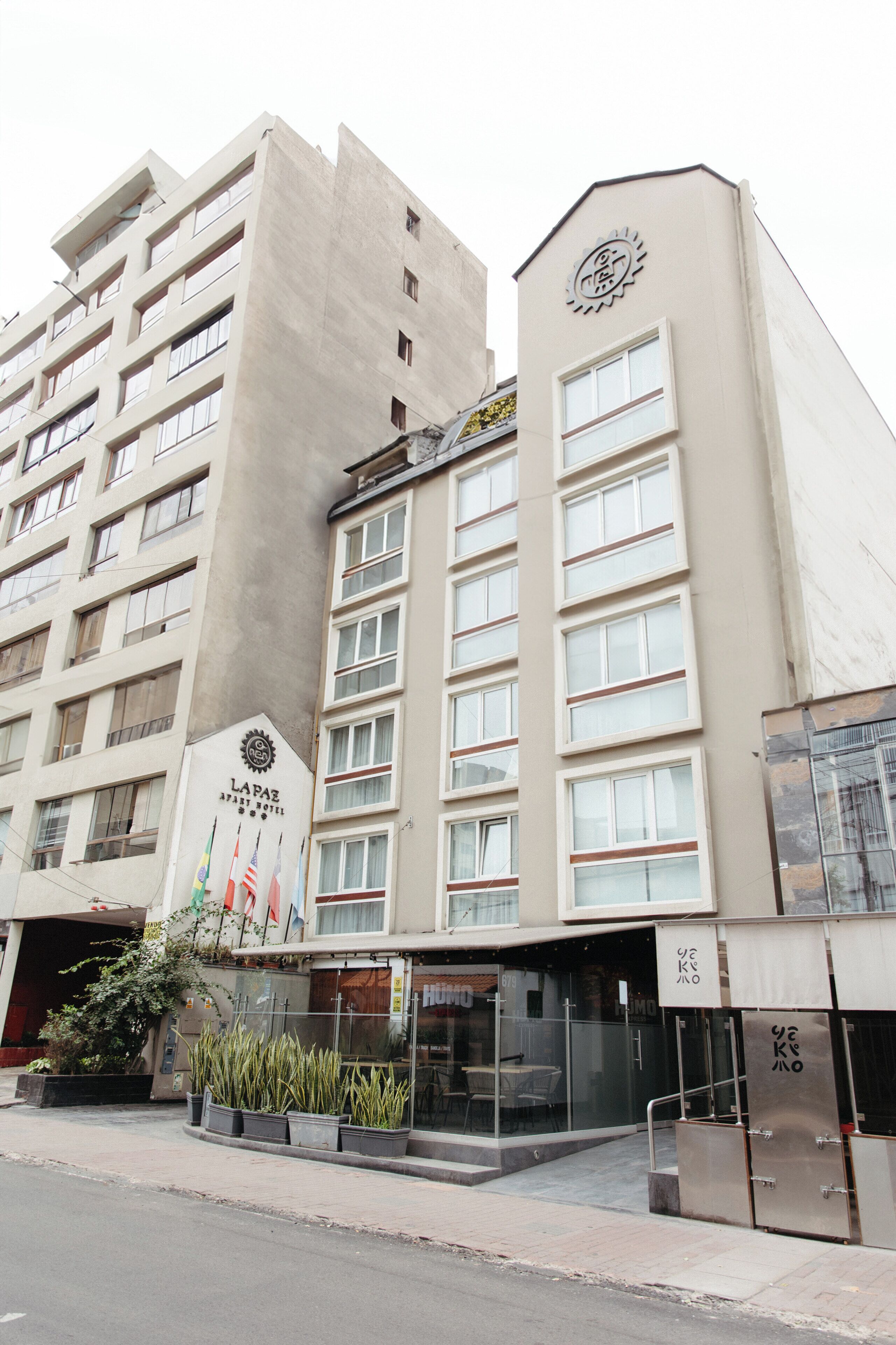 A hotel with a modern facade, multiple windows, and a visible entrance with a glass door.