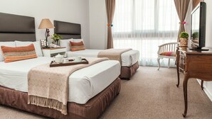 A hotel room with two beds, a desk with a TV, a chair, and a window with curtains. - La Paz Apart Hotel (Lima)