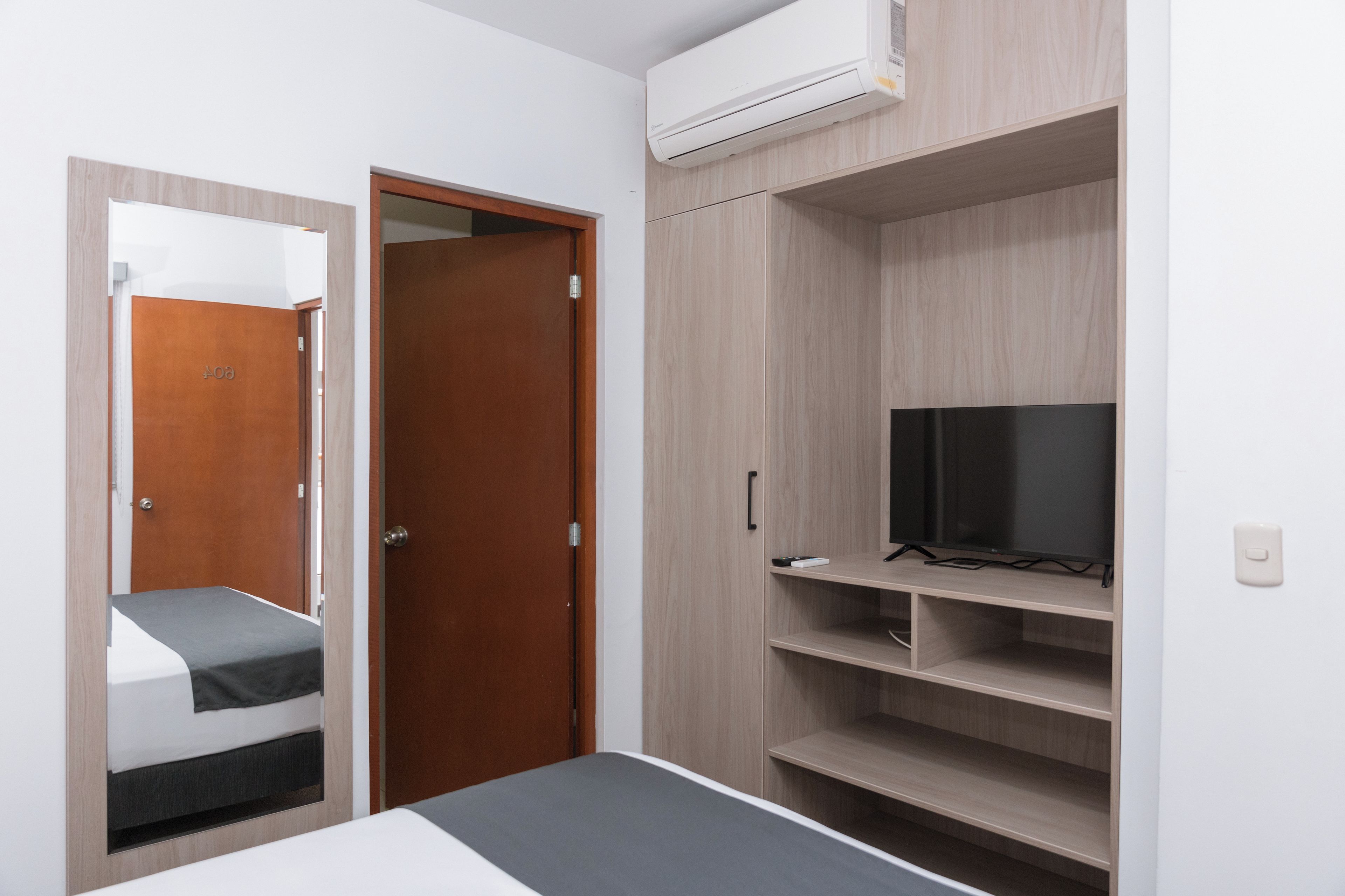Une chambre à coucher avec un lit, une armoire et un téléviseur.