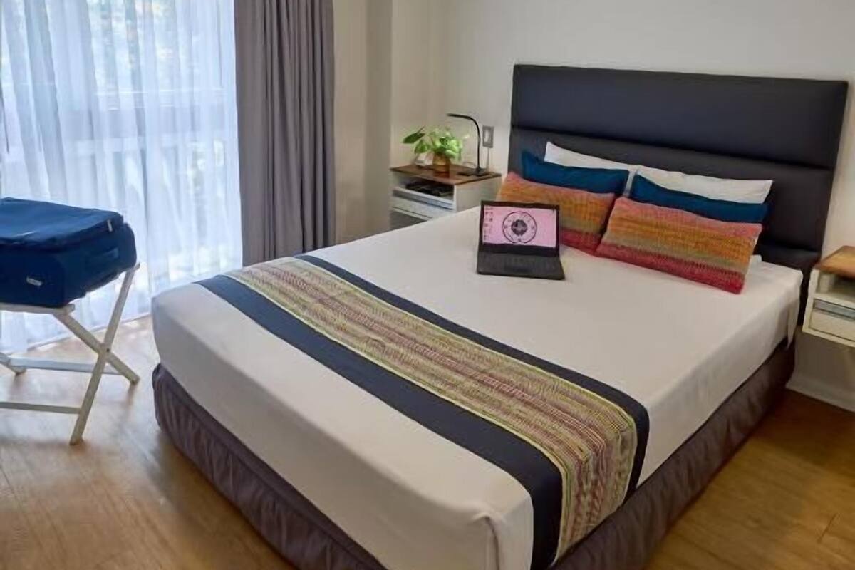 Een keurig ingerichte hotelkamer met een groot bed, een bureau en een stoel.