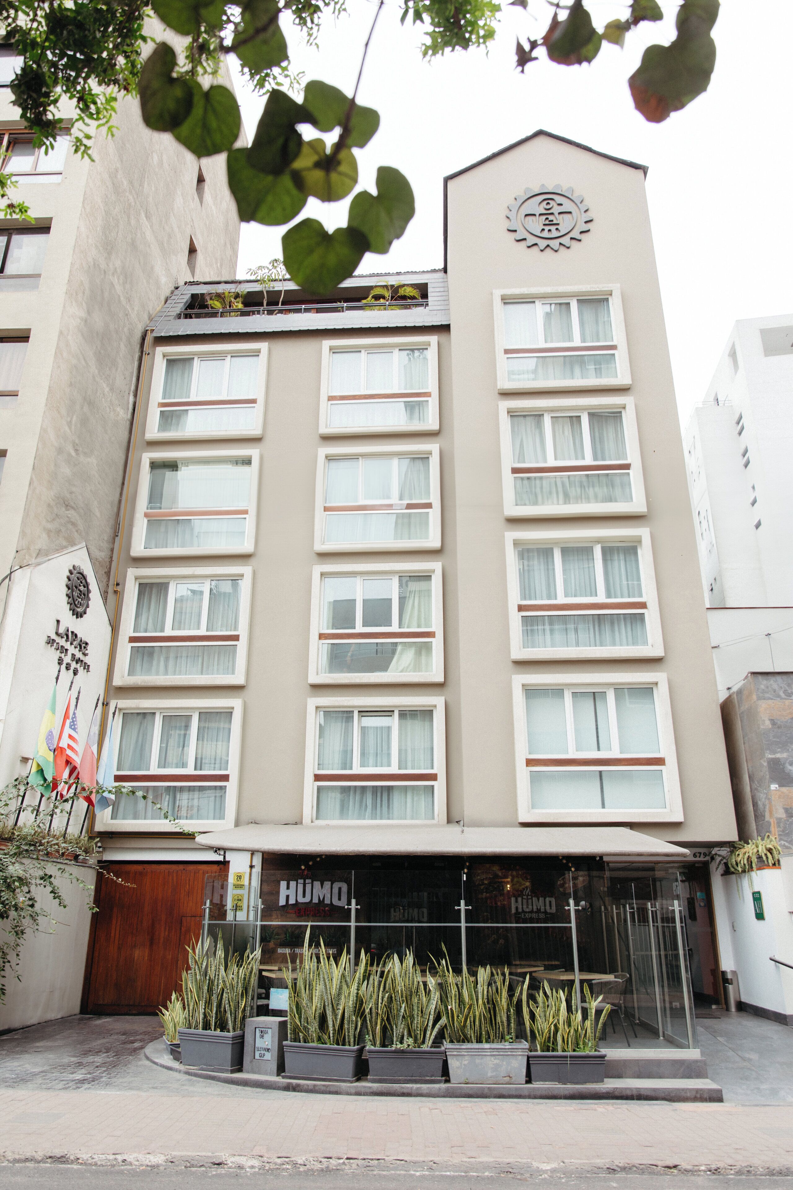 A multi-story hotel with a central entrance, a clock on the facade, and a sign reading 'HUMO.'