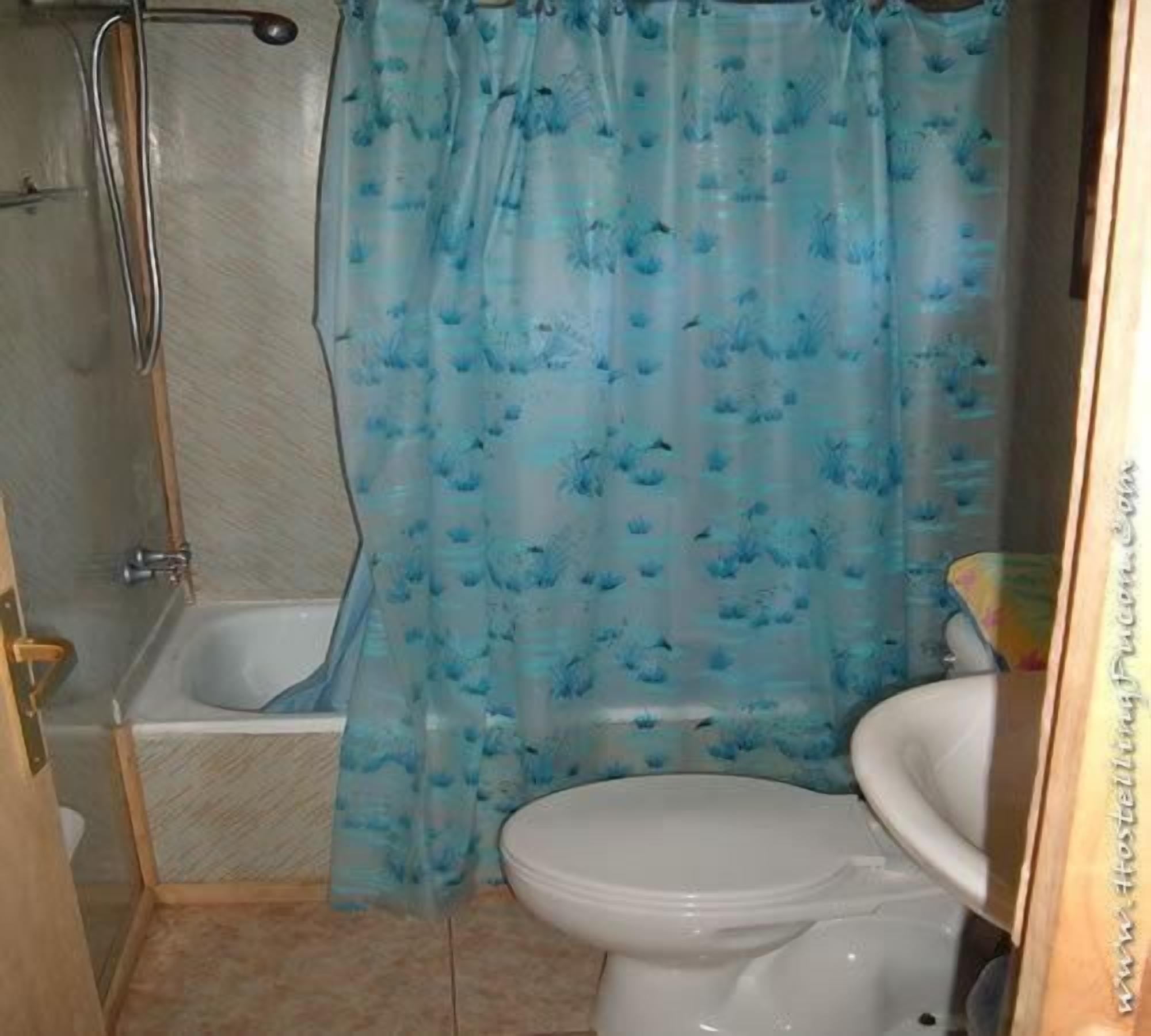 Un baño con bañera, inodoro y cortina de ducha.
