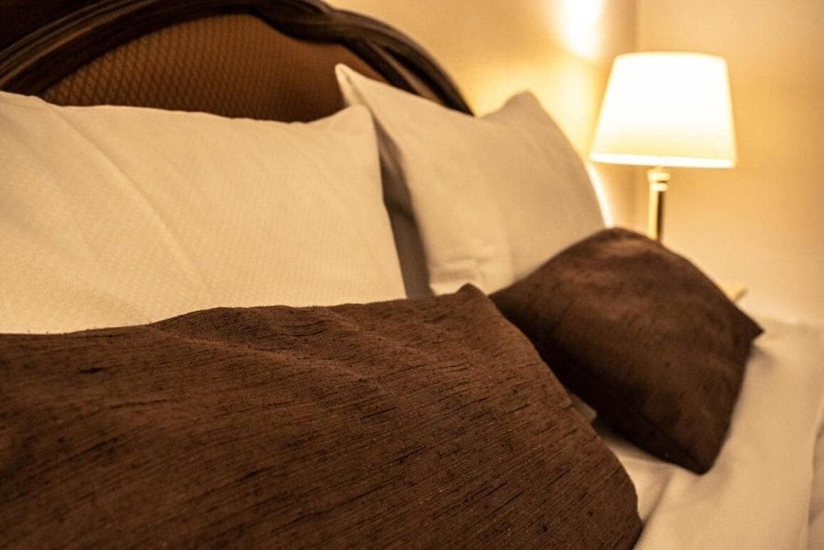 A bed with white and brown pillows and a headboard.