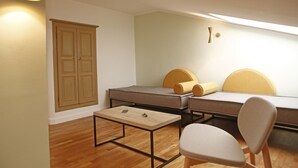 A compact room with a bed, a desk, a chair, and a wardrobe. - Hotel Balanea (Calvi)