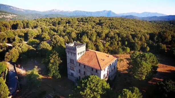 A castle-like building surrounded by dense forest, with a mountainous backdrop. - Sole e Monti (Quenza)